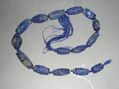 a necklace made of blue glass beads on a table