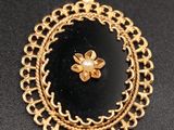 un pendentif doré et noir orné d'une fleur