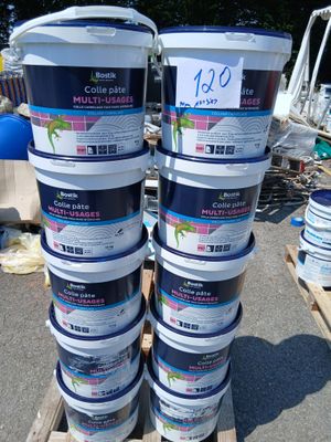 plusieurs seaux de peinture posés sur une palette