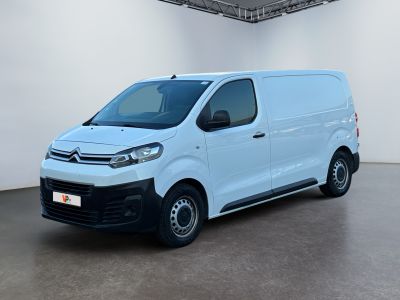 Une camionnette blanche est garée dans une grande pièce.