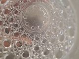a person holding a glass of water with bubbles in it
