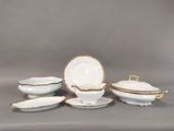 a white and gold plate with a bowl and a saucer