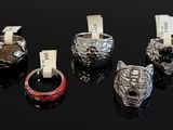 five different rings with tags on them sitting on a black surface