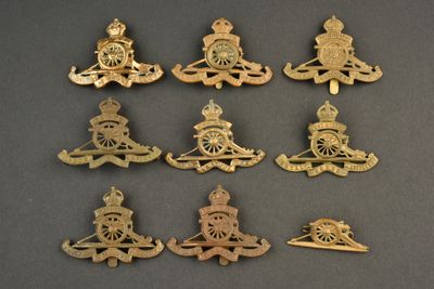 six pairs of royal military badges on a black surface