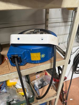 une machine bleue posée sur une étagère dans un garage