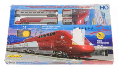 un train rouge et blanc sur des rails, dans une boîte