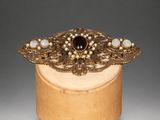 a close up of a wooden box with a broochet on it