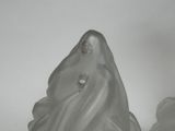 a glass figurine of a ghost sitting on a table