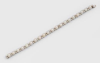 gros plan d'un bracelet avec des perles sur une surface blanche