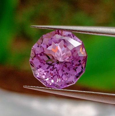 someone is holding a pair of pliers with a purple diamond in it