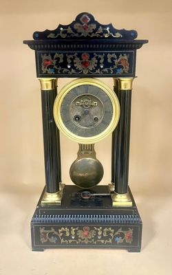 a black and gold clock sitting on top of a table