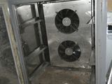 une armoire métallique équipée de ventilateurs, située dans une pièce