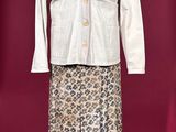 a white jacket and skirt on a mannequin stand