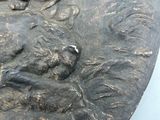 a close up of a metal plate with a bird on it
