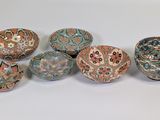six different colored bowls sitting on top of each other on a table