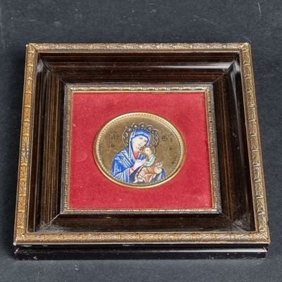 an old picture of a woman holding a baby in a wooden frame