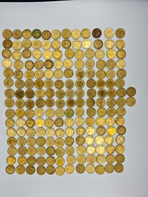a white plate topped with lots of gold coins on top of a table