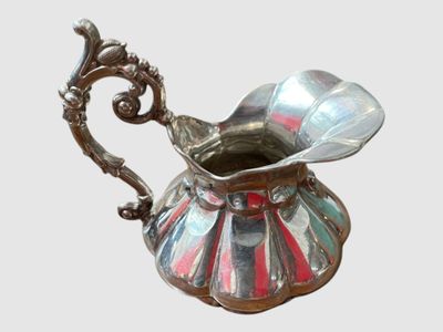 un pichet en argent orné d'une rayure rouge et blanche