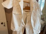 a white shirt hanging on a wooden hanger in front of a mirror
