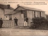 une vieille photo montrant un groupe d'hommes debout devant une maison