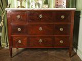 a wooden dresser with a marble top in a room with green walls