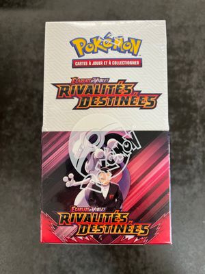 a box of pokemon trading cards with a picture of a man holding a sword