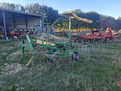 a green tractor that is parked in the grass