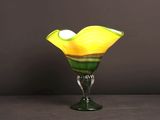 un vase en verre contenant une fleur jaune et verte