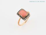 un gros plan d'une bague sertie d'une pierre rose