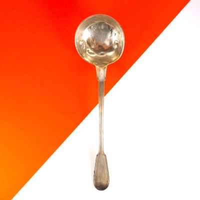une cuillère posée sur une table orange et blanche