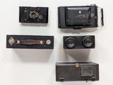 four different types of old cameras on a white surface