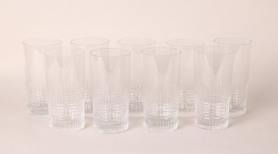 six clear glasses lined up in a row on a white surface
