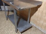 une table en métal avec une étagère posée dessus, dans une pièce
