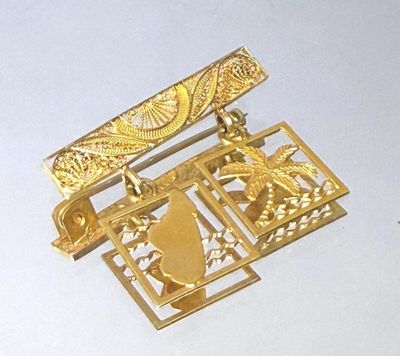 a picture of a gold brooch with a bird on it
