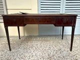 a wooden desk with a drawer on it in front of a door