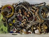 a plastic container filled with assorted jewelry and bracelets