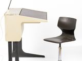 a desk with a chair and a lamp next to it