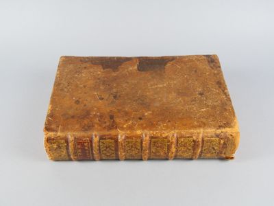 un vieux livre posé sur une surface blanche