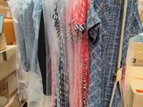 a lot of clothes hanging on a rack in a room