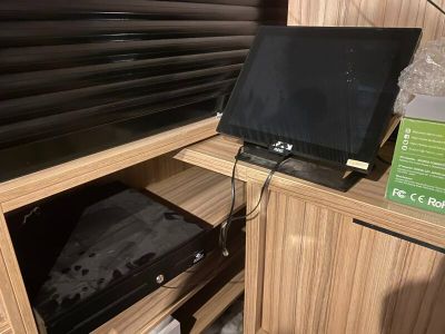 a laptop sitting on top of a wooden cabinet