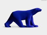 a blue bear that is standing on a white surface