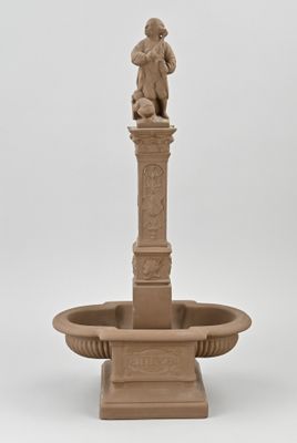 a statue of a man sitting on top of a fountain