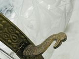 a glass jar with a metal handle on a white surface