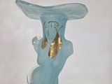 a blue glass vase with a gold leaf on it