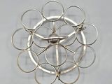 a clock made out of metal rings on a gray surface
