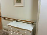 une commode blanche dans un coin de la pièce