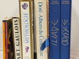 several books are lined up on a white surface with a blue ribbon