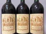 trois bouteilles de vin rouge posées sur une table blanche