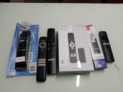 three remotes sitting on a table next to each other