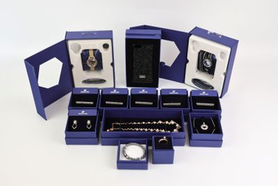 de nombreux bijoux dans une boîte bleue posée sur une surface blanche